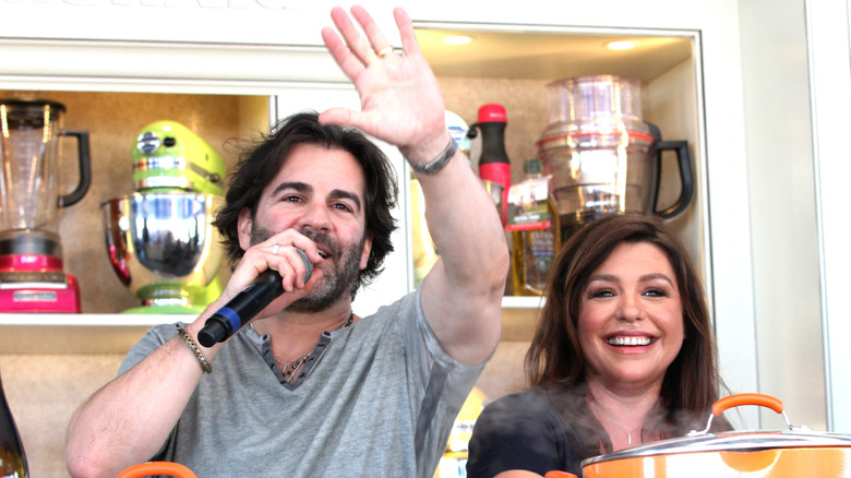 Rachael Ray smiles and John Cusimano speaks into mic during culinary demonstration in 2014