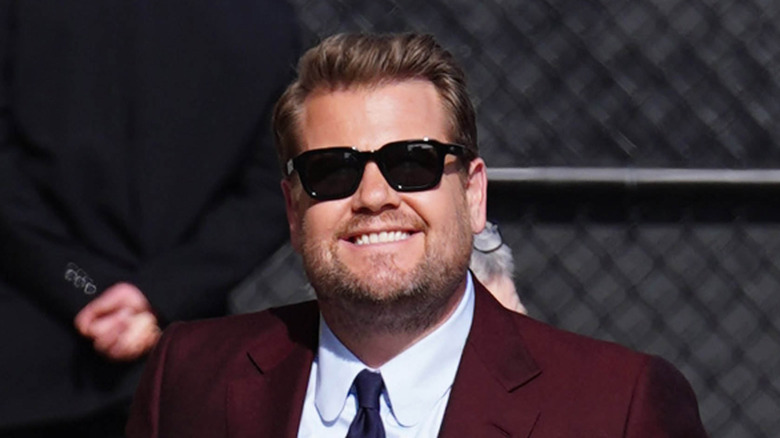 James Corden is seen on April 24, 2023, in a mahogany suit.