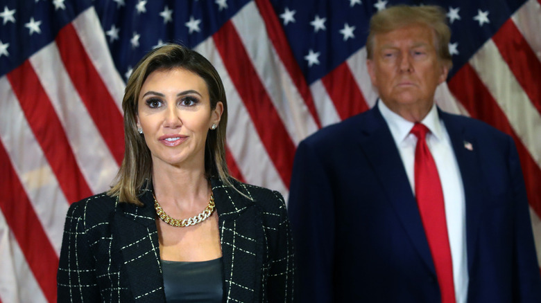 Donald Trump standing with his lawyer Alina Habba as she speaks to the media