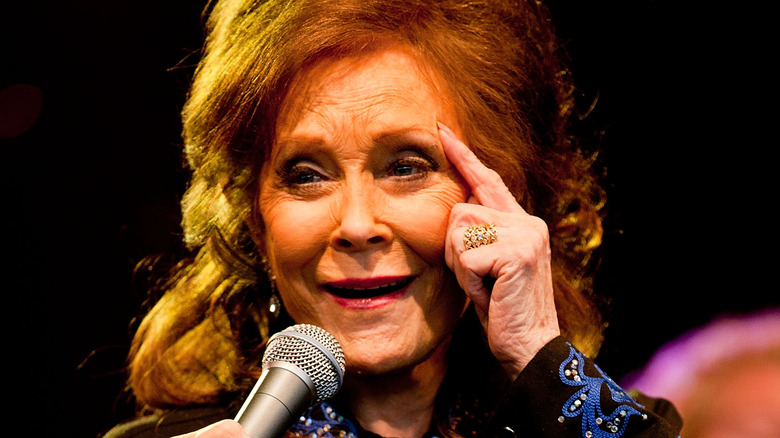 Loretta Lynn touching forehead