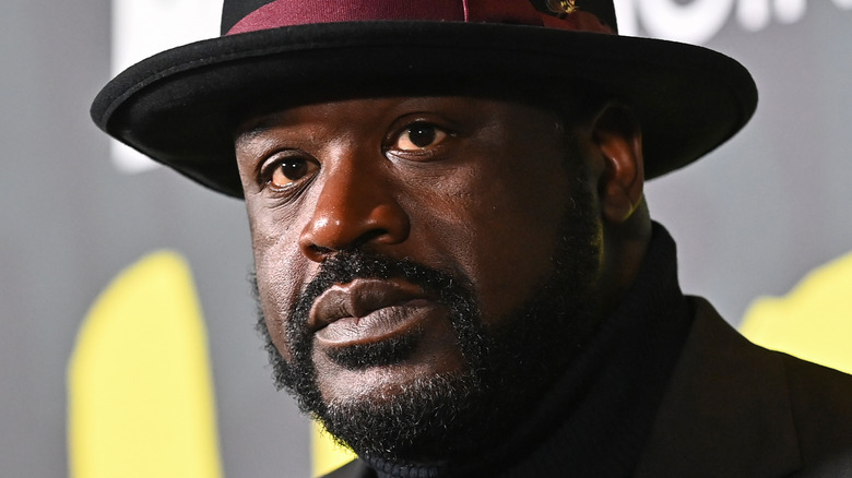 Shaquille O'Neal wears a hat, turtleneck and blazer