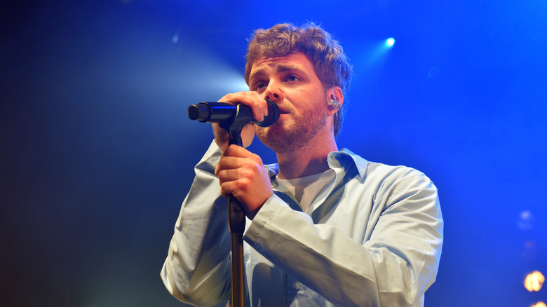 Alex Warren singing into a microphone