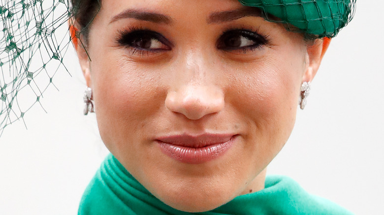 Meghan Markle smiling in green hat