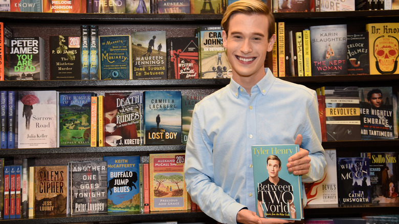 Tyler Henry holding his book