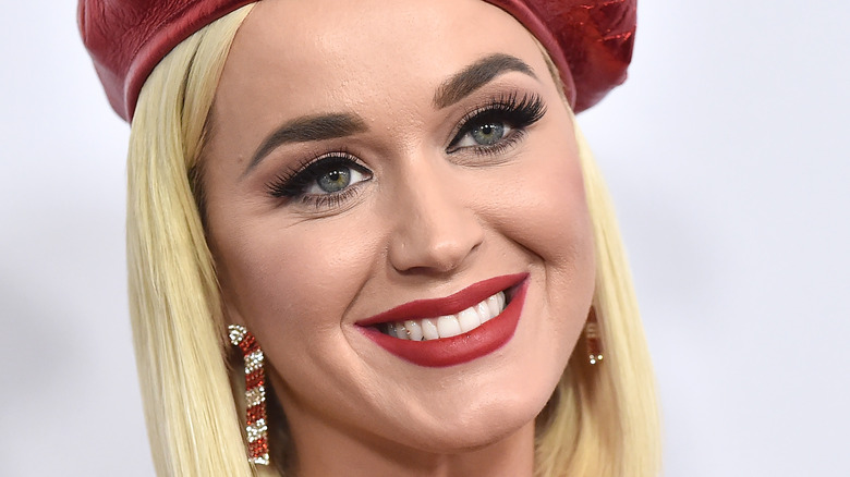 Katy Perry poses in red beret and lipstick.