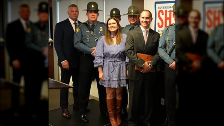 Sarah Huckabee Sanders posing with Arkansas law enforcement officers.