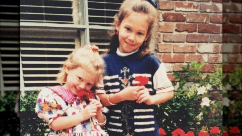 Hilary Duff and Haylie Duff with flowers during their childhood