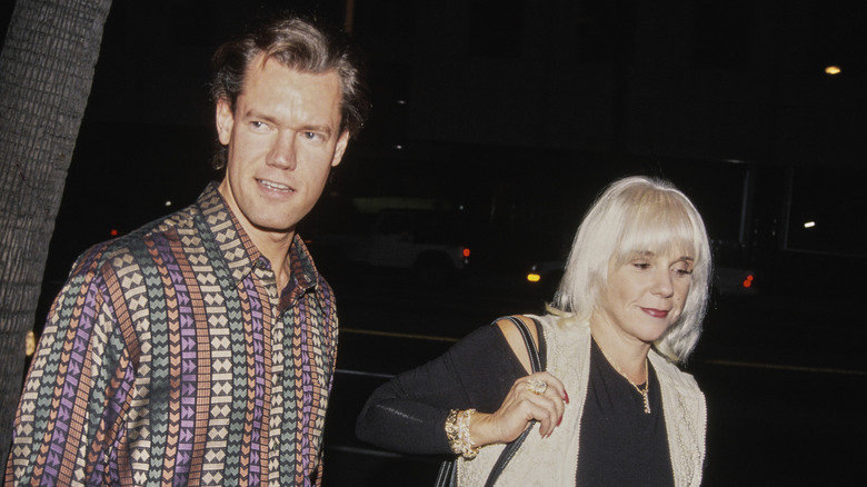 Randy Travis and Lib Hatcher walking down the street