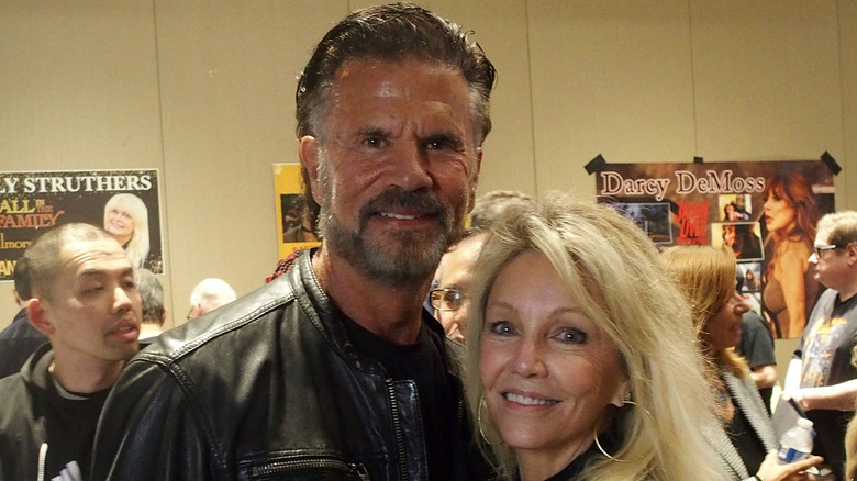 Lorenzo Lamas in a black leather jacket and Heather Locklear wearing large hoop earrings