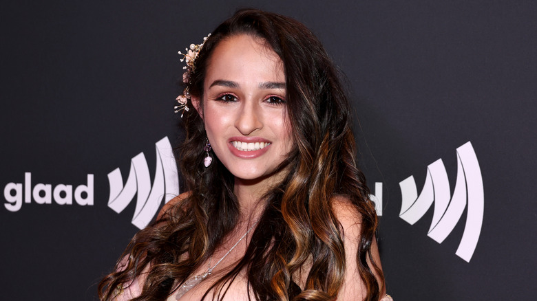 Jazz Jennings, sporting a blended hair color and a headpiece, is all smiles at a Glaad event.
