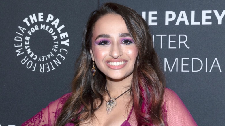 Jazz Jennings wearing vibrant makeup and flashing a bright smile at The Paley Center for Media event.