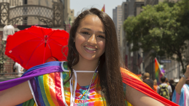 Jazz Jennings smiling while wearing a rainbow-themed outfit at the New York City Pride Parade.