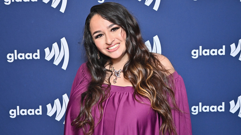 Jazz Jennings beaming with a broad smile while tilting her head to the side at a Glaad event.