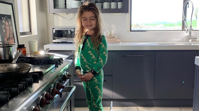 Reign Disick smiling in front of oven