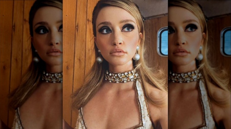 Francesca Xuereb posing in large pearl drop earrings and a dress with a bejeweled choker-style collar.