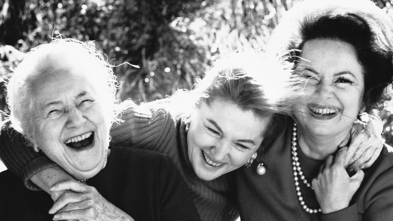Lillian Fontaine, Olivia de Havilland, and Joan Fontaine posing for cameras