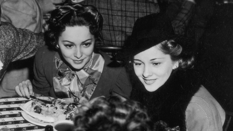 Olivia de Havilland and Joan Fontaine in restaurant in 1940s
