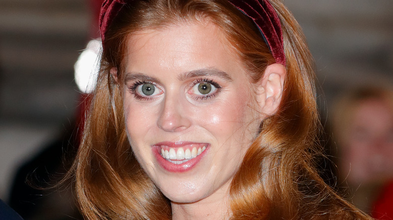 Princess Beatrice wearing maroon headband, smiling