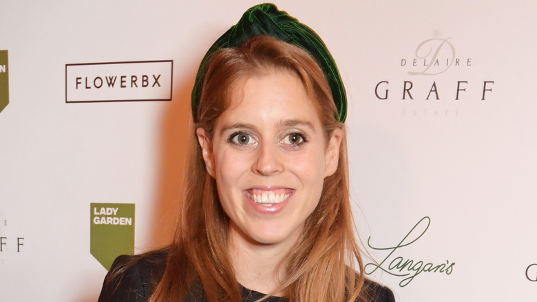 Princess Beatrice smiling, wearing green headband