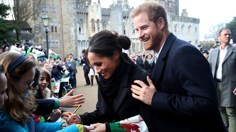 Meghan Markle signs autograph