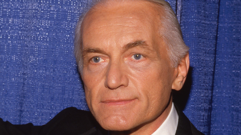 Closeup of Ted Knight in front of a blue background