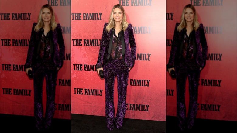 Michelle Pfeiffer smiling and posing at the premiere of The Family.