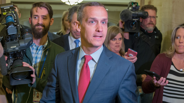 Corey Lewandowski flanked by reporters.