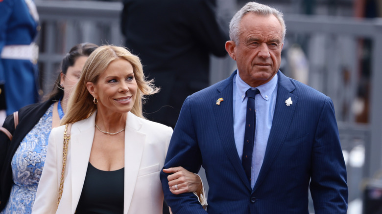 Cheryl Hines gazes up at RFK Jr. as they walk arm-in-arm.