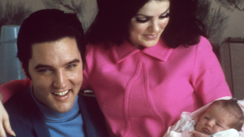 Elvis and Priscilla Presley holding daughter Lisa Marie Presley