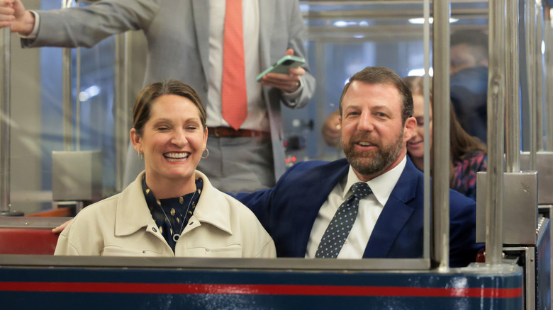 Markwayne Mullin and his wife smiling while riding the subway