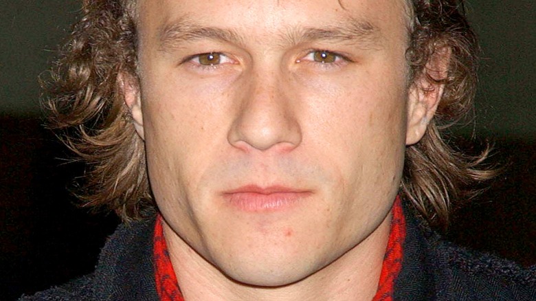 Heath Ledger poses in red shirt