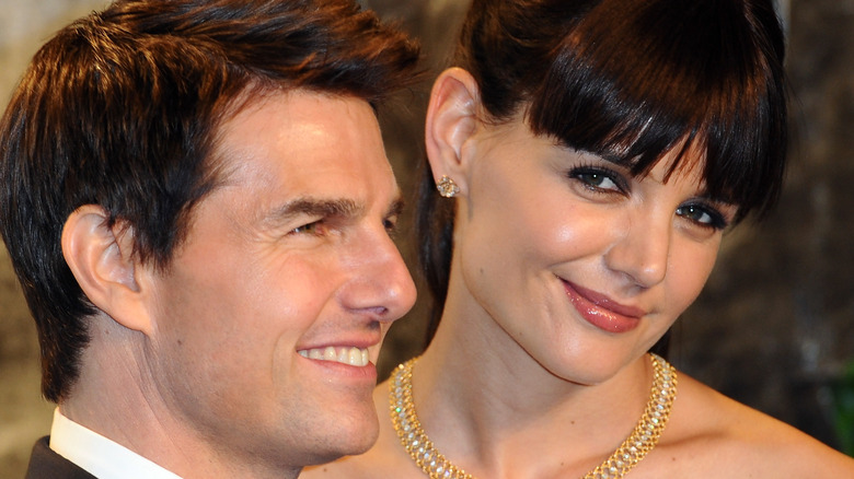 Tom cruise looking sideways Katie Holmes smiling at camera