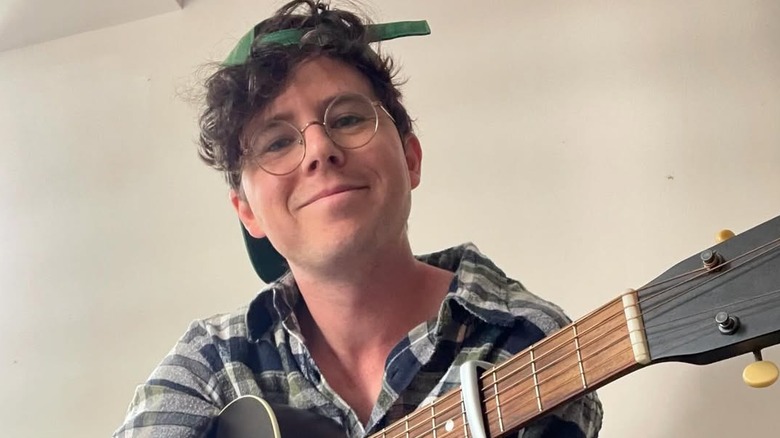 Charlie McDermott posing for cameras with guitar