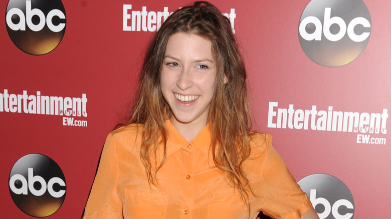 Eden Sher poses in an orange shirt in 2013.