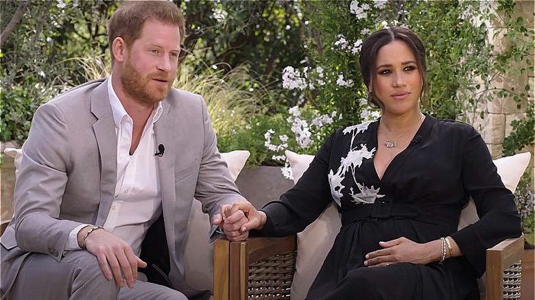 Prince Harry talking Meghan Markle watching in black dress