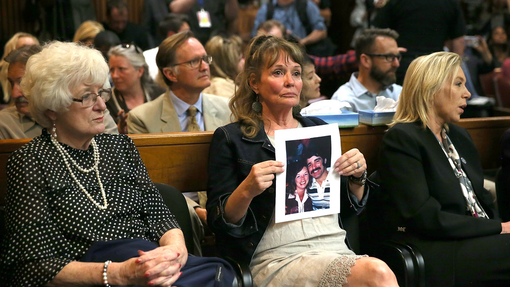 An attendee holds a photo of victims Cheri Domingo and her boyfriend Gregory Sanchez