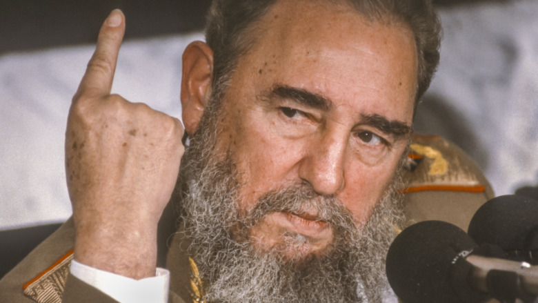 Fidel Castro speaking into a microphone and pointing up