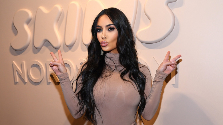 Kim Kardashian pouting while throwing up peace signs