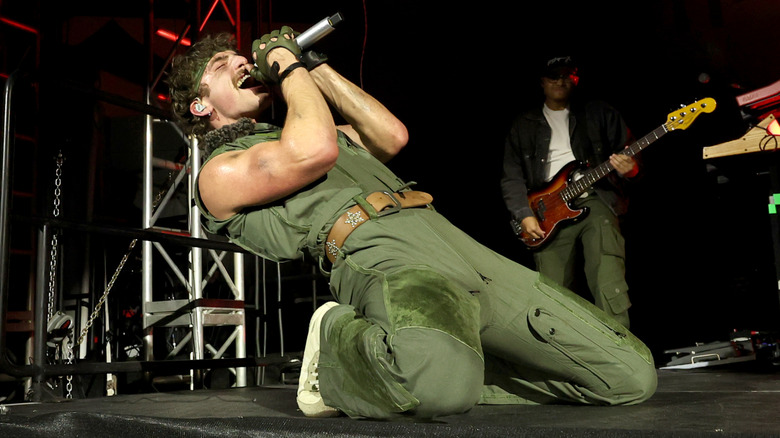 Benson Boone singing in green jumpsuit