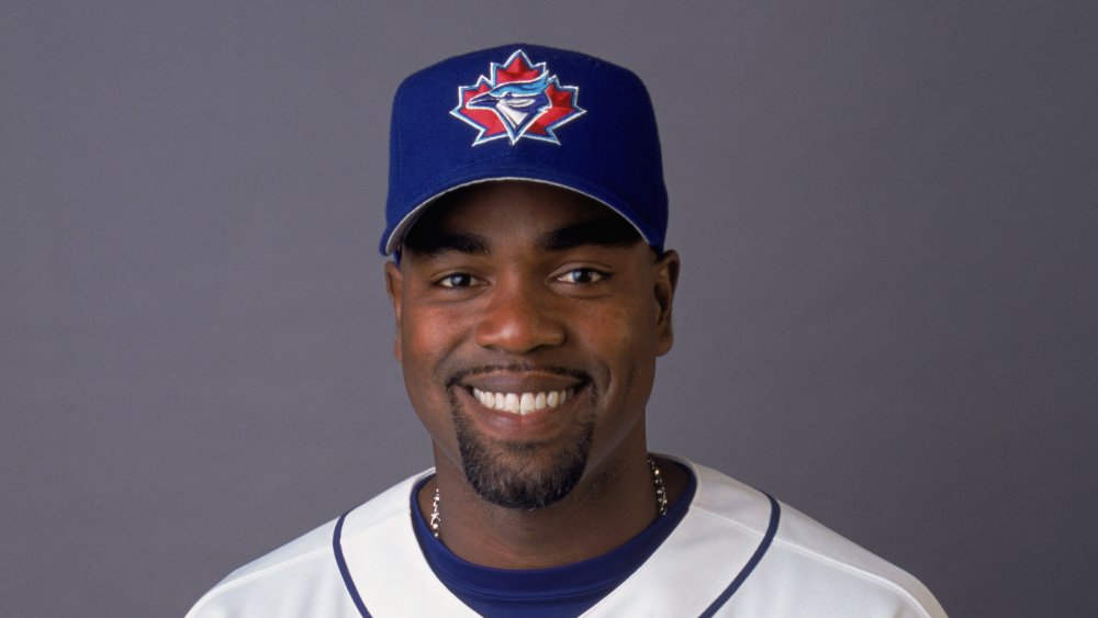 Carlos Delgado with Blue Jays jersey and hat, smiling