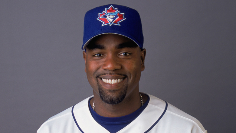 Carlos Delgado with Blue Jays jersey and hat, smiling