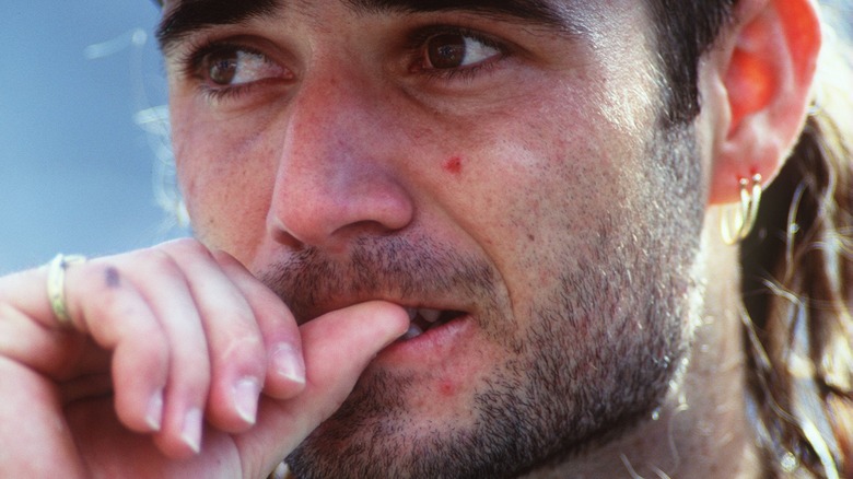 Andre Agassi biting his thumb