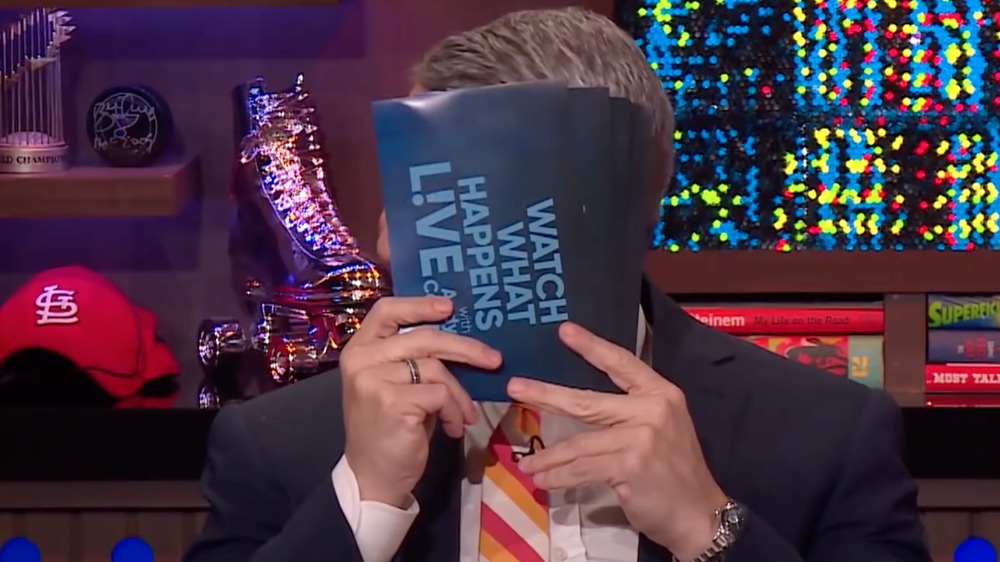 Andy Cohen hiding his face behind note cards