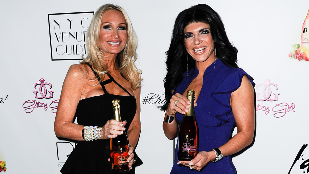 Kim DePaola and Teresa Giudice holding wine 