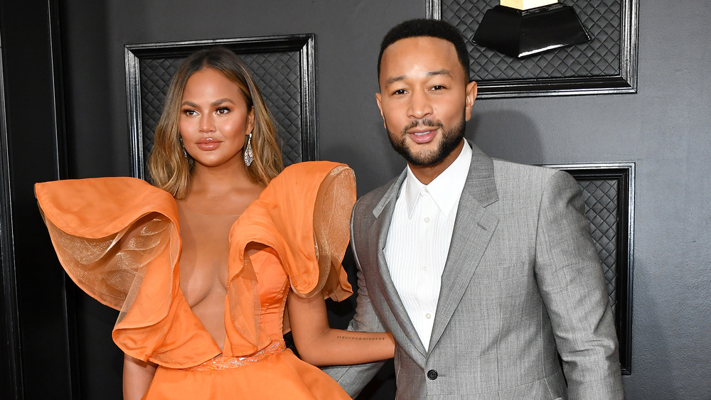 Chrissy Teigen and John Legend posing arm in arm