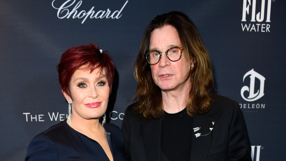 Sharon Osbourne and Ozzy Osbourne posing arm in arm