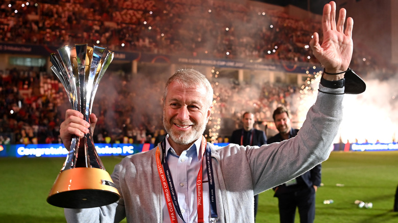 Roman Abramovich holds the FIFA trophy and waves