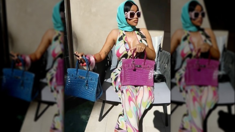Cardi B posing with two of her Hermés Birkin bags. 