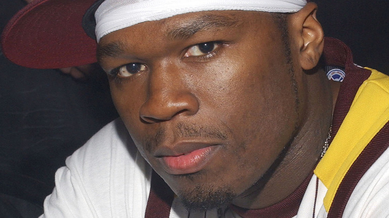 A young 50 Cent wearing a burgundy cap 