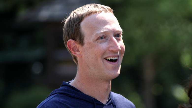 Mark Zuckerberg is all smiles in a navy blue sweatshirt